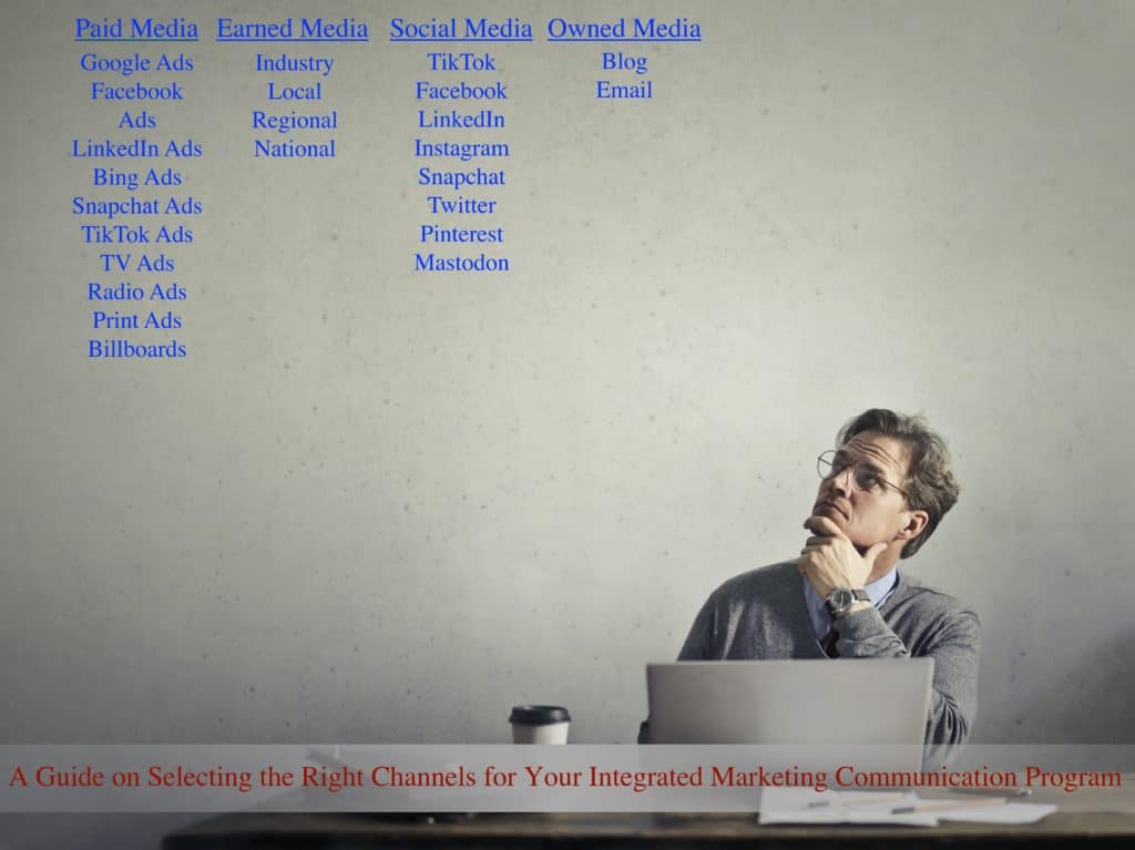 Man on a laptop looking  up at his integrated marketing communication channel options